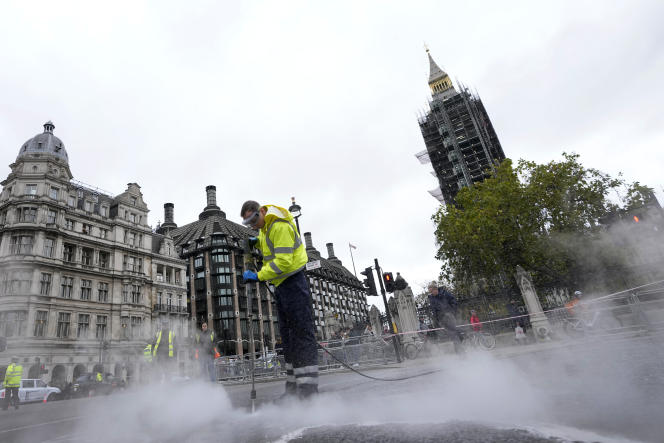 A cleaner removes sludge from the road outside the Houses of Parliament on November 4, 2021, following protesters sticking to isolate Britain in Dormac, London.