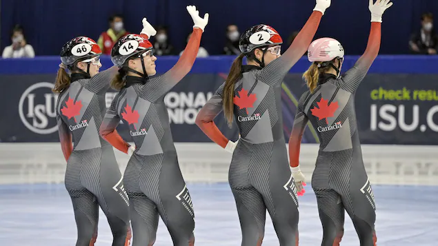 In perfect synchrony, the four girls greet the crowd by raising their right hands.