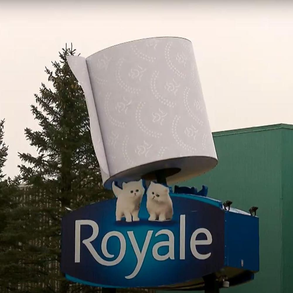 Giant toilet paper roll in front of a building.